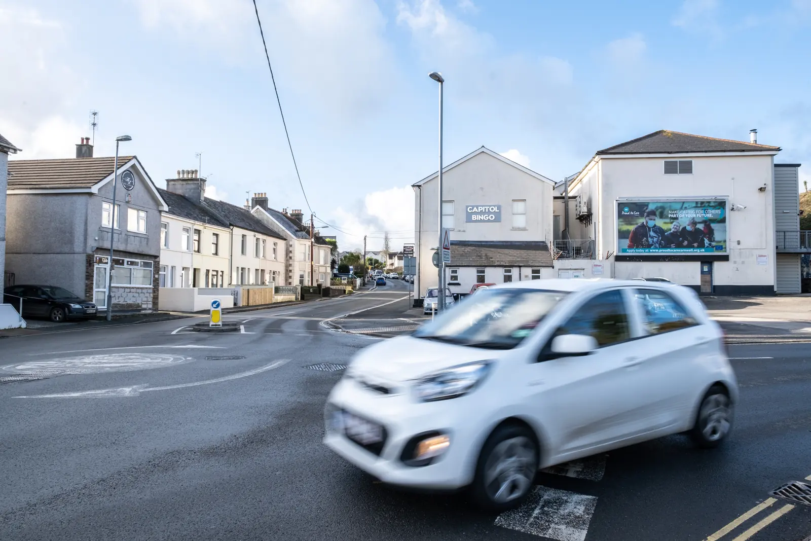 A car at the Alexandra Road junction in St Austell with the billboard in the background