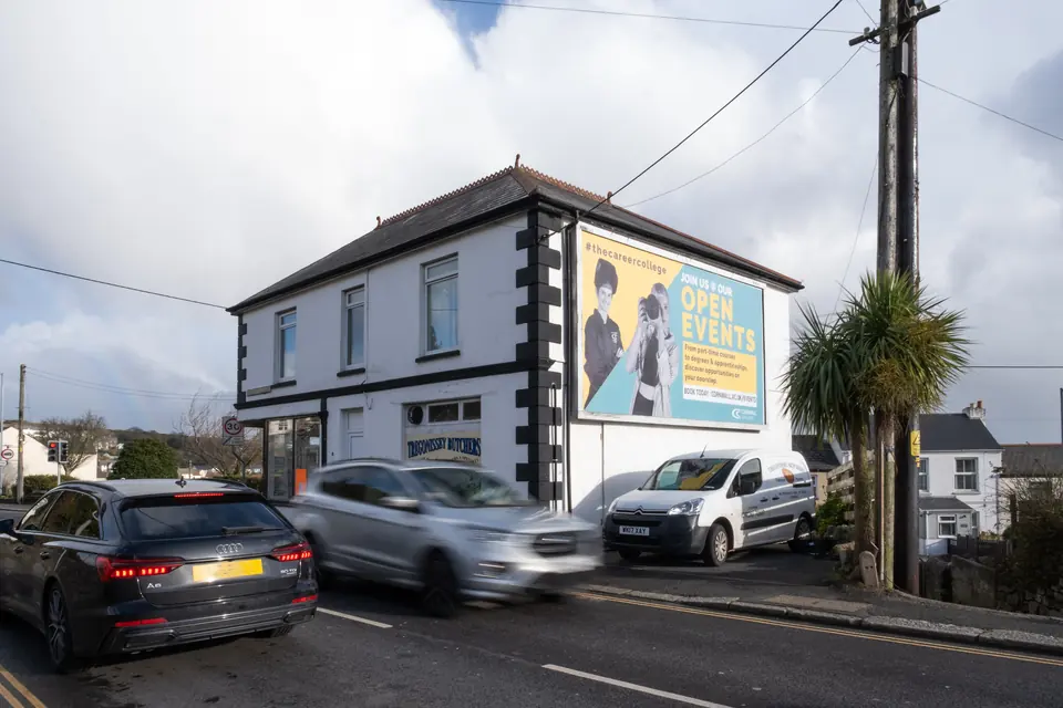 Cars passing the Tregonissey Road billboard in St Austell